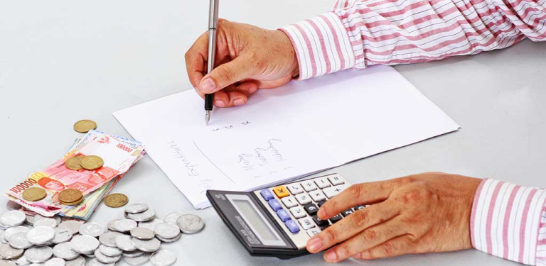 seseorang mencatat laporan keuangan untuk cara pintar mengatur finansial dan keuangan usaha.