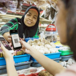 Pemilik UMKM melayani pelanggan dengan teknologi digital untuk transaksi modern